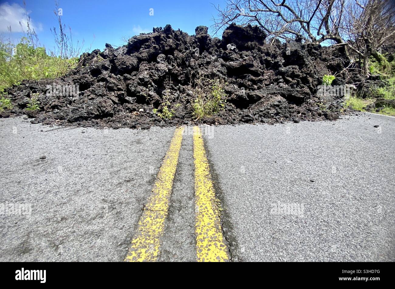 Lava, ora solidificata, che fluì su e bloccava una strada nel Parco di Isaac Hale Beach (conosciuto localmente come Pohoiki) nella regione di Puna della Grande Isola delle Hawaii dopo l'eruzione del 2018 di Kilauea Foto Stock