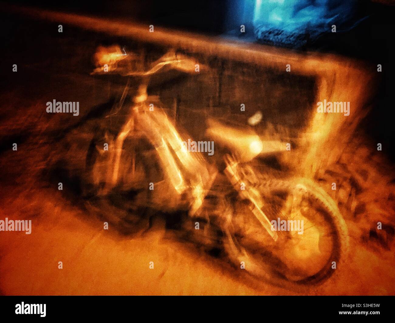 Immagine spettrale di una bicicletta lasciata in strada di notte Foto Stock
