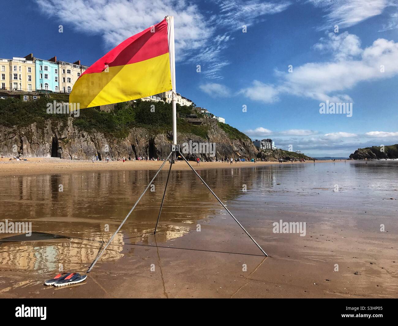 La bandiera rossa sopra gialla indica una zona balneare consigliata che è monitorata da bagnini - Tenby Wales Foto Stock