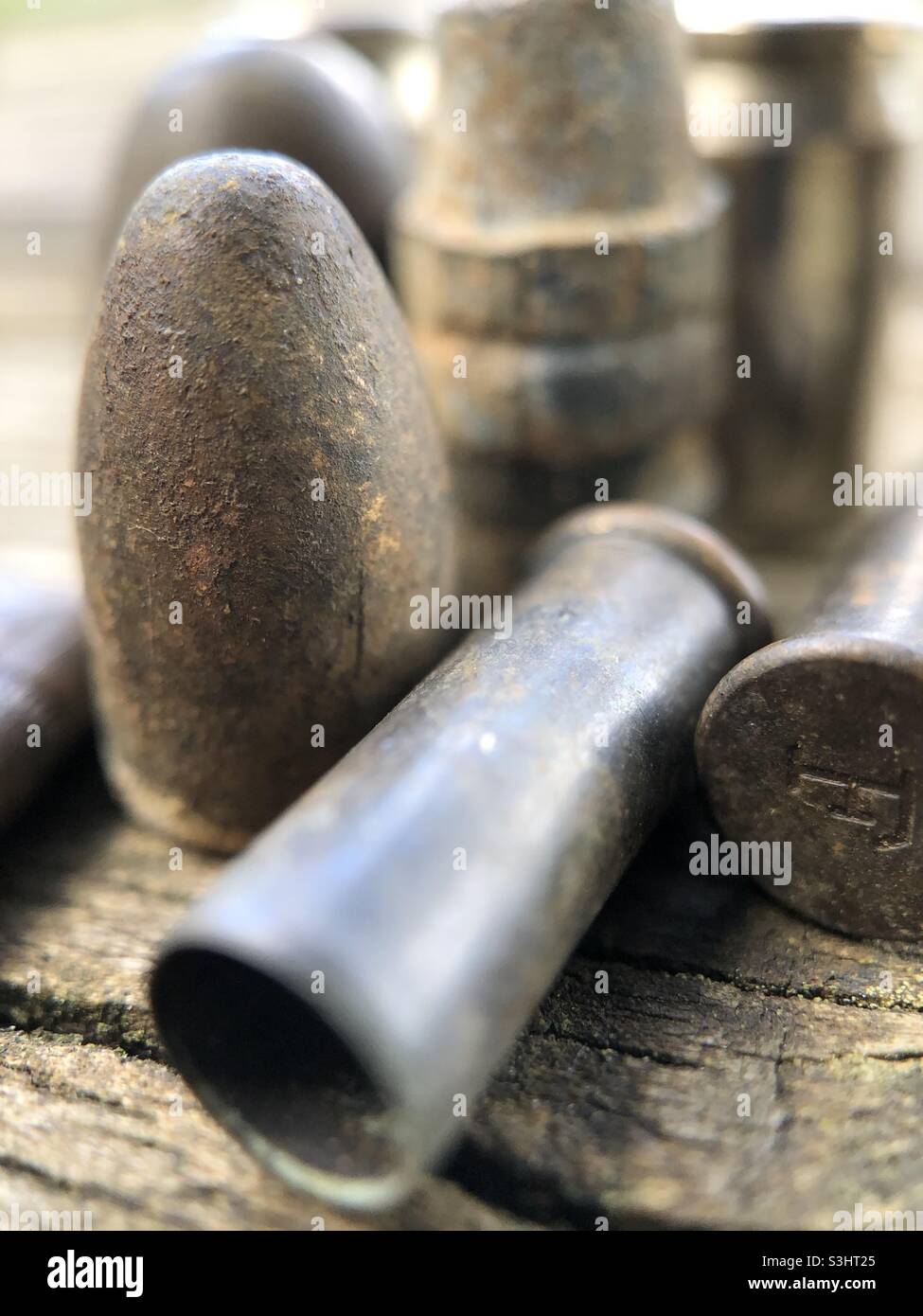 Vecchie pallottole e involucri di guscio su un pezzo di legno. Foto Stock