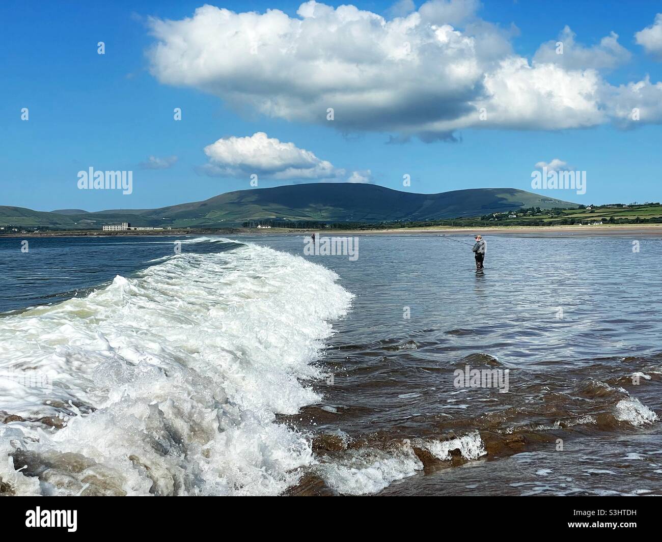 Pesca al branzino su una spiaggia di surf irlandese, agosto. Foto Stock