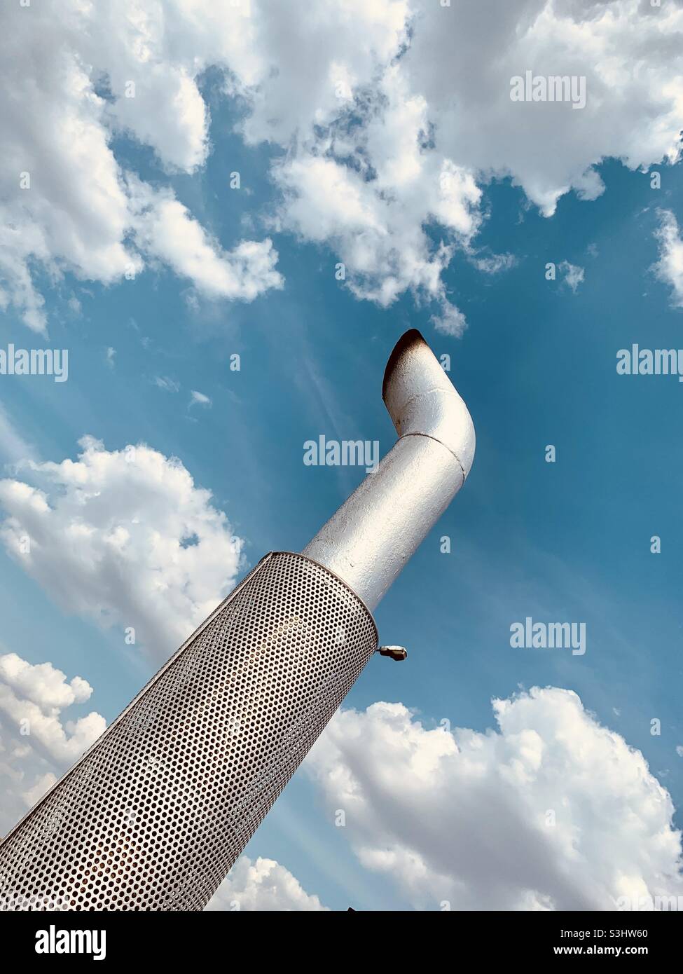 Camino industriale metallico contro cielo nuvoloso - Immagine stock catturata con smartphone