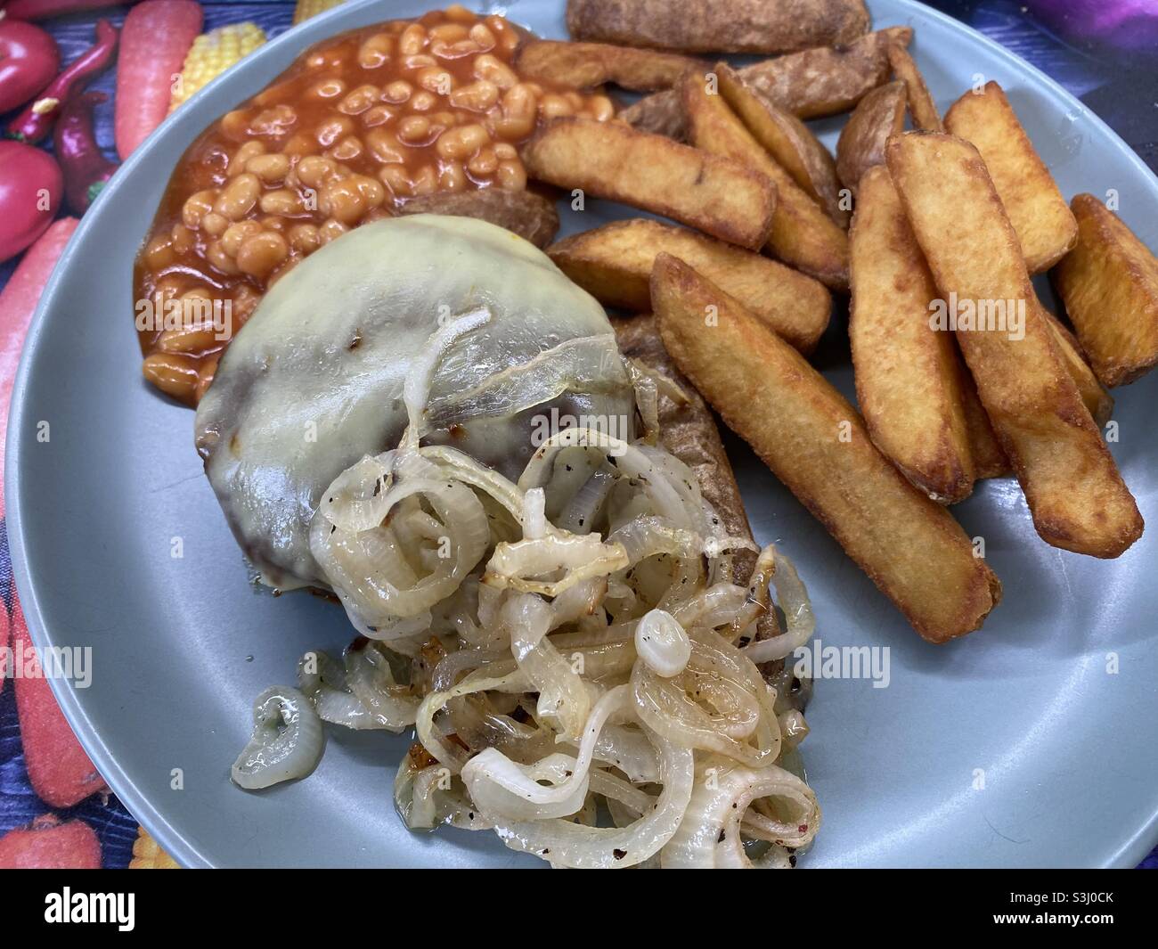 Hamburger al formaggio, fagioli, cipolle fritte, patatine fritte triple Foto Stock