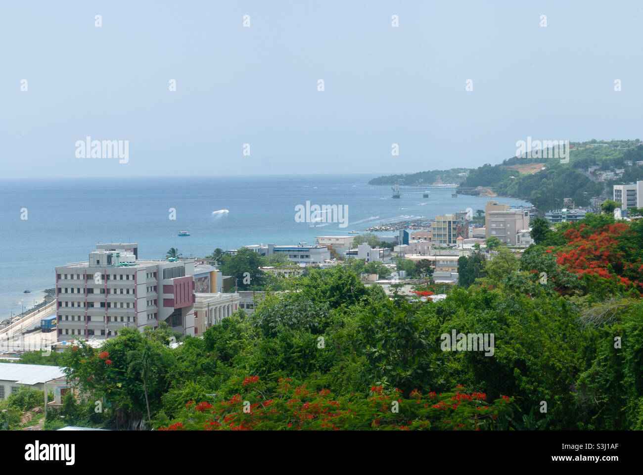 Vista su una costa caraibica con montagne ed edifici - Aguadilla, Porto Rico Foto Stock