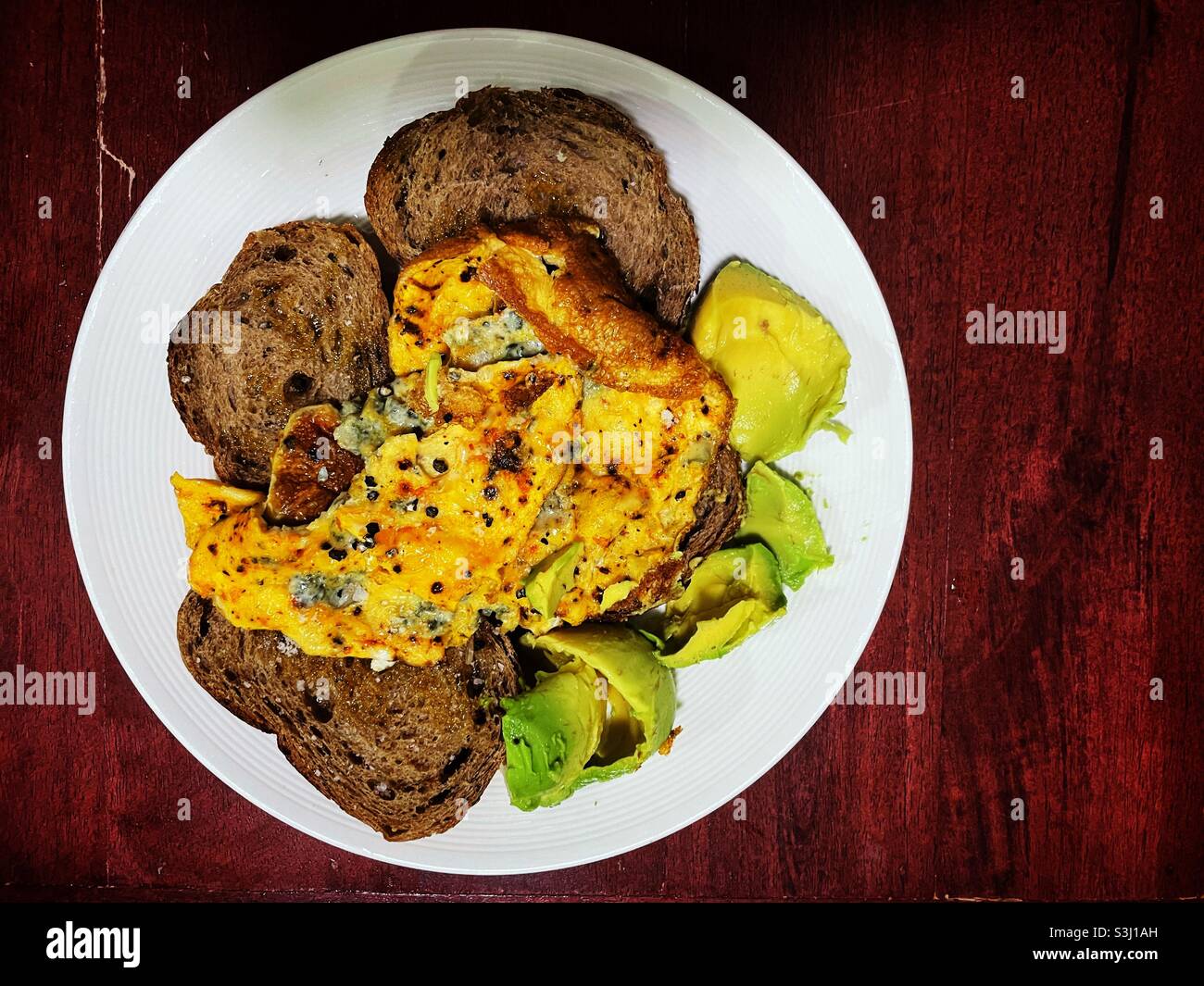 Misto di sheesh e omelette al peperoncino su brindisi bruno con avocado Foto Stock