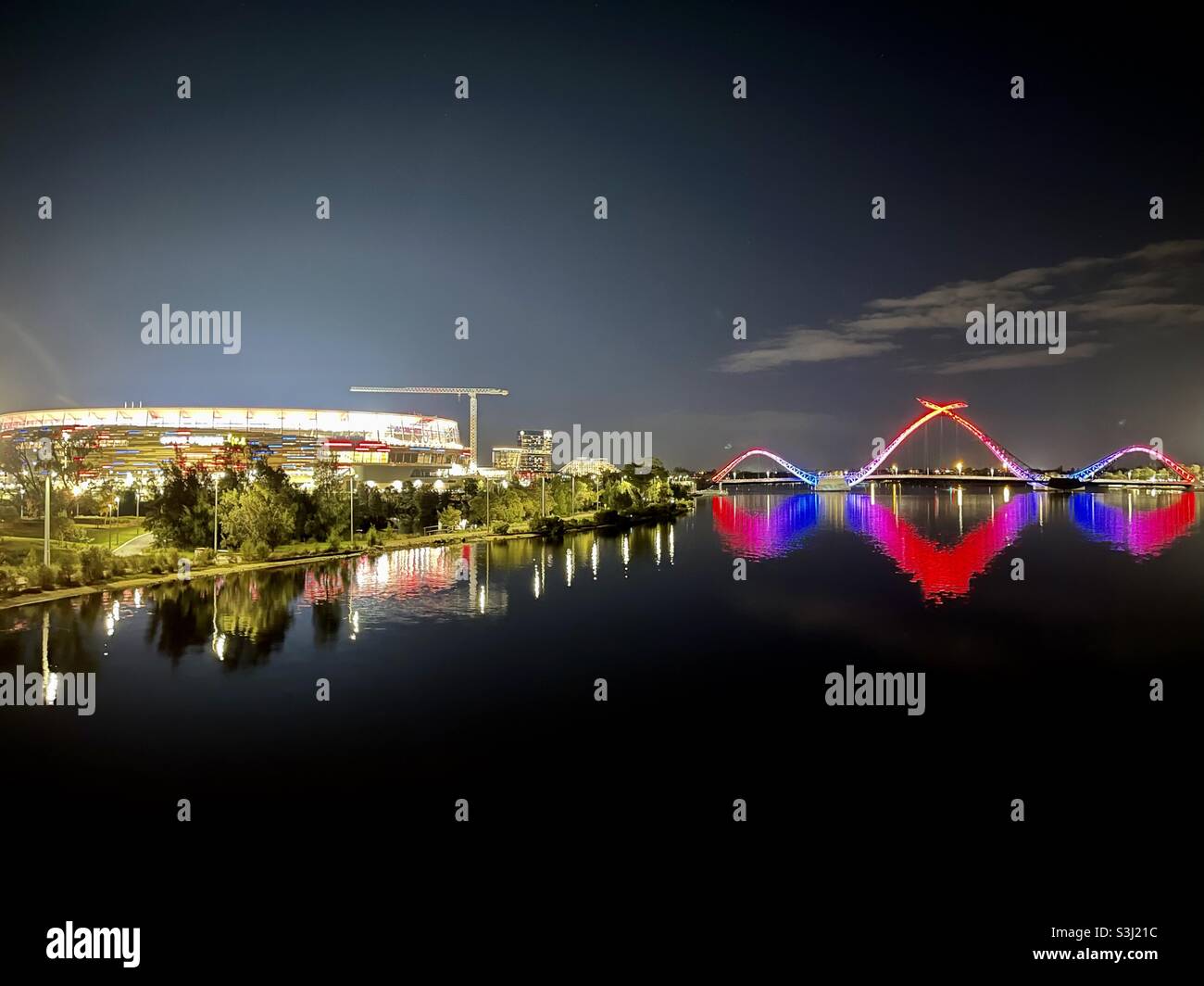 Optus Stadium e Matagarup Bridge si illuminano nei colori del Melbourne Football Club in occasione della vittoria della finale preliminare AFL 2021 a Perth in Australia Occidentale Foto Stock