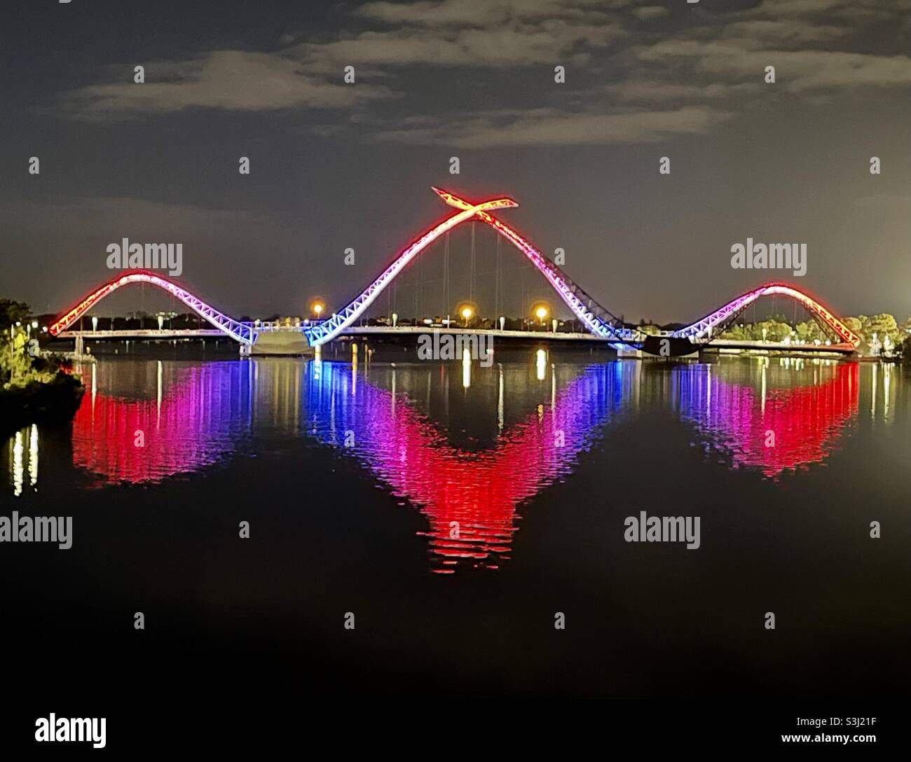 Il ponte Matagarup si è illuminato nei colori del Melbourne Football Club che si riflettono sul fiume Swan in occasione della vittoria della finale preliminare AFL 2021 a Perth Australia Occidentale Foto Stock