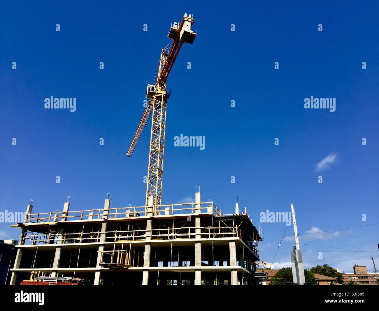 Costruzione moderna con alta gru su un pomeriggio di cielo blu, Halifax, Canada. Costruzione in corso. Foto Stock