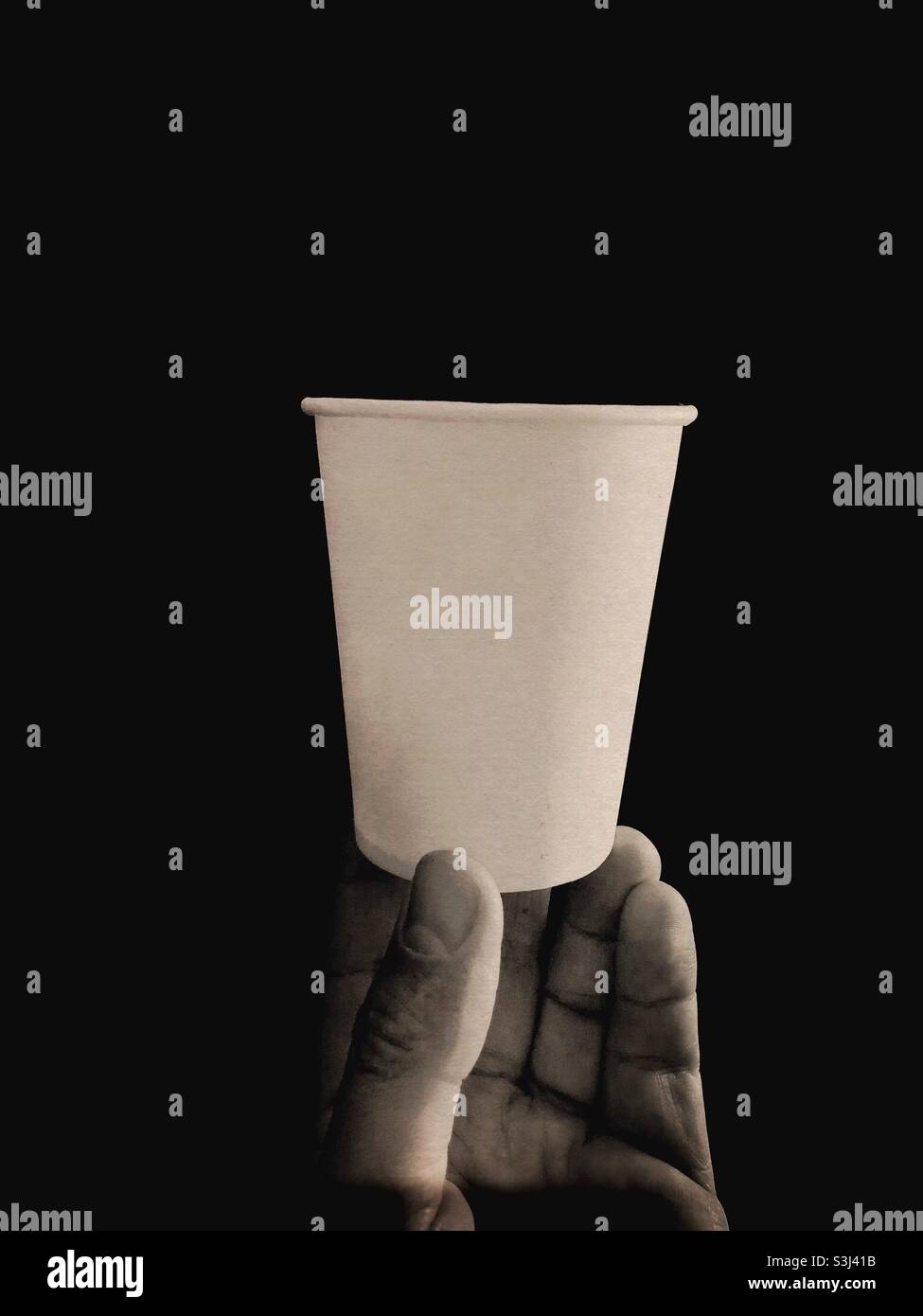 Mano che tiene una tazza di carta Foto Stock