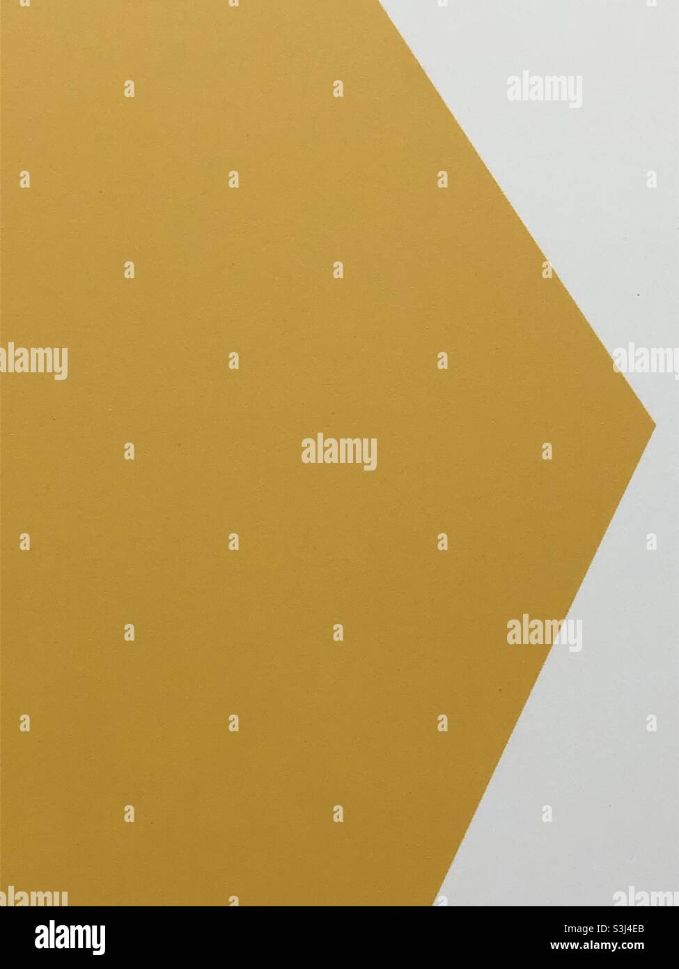 Primo piano con freccia gialla sulla parete bianca - Immagine stock catturata con smartphone