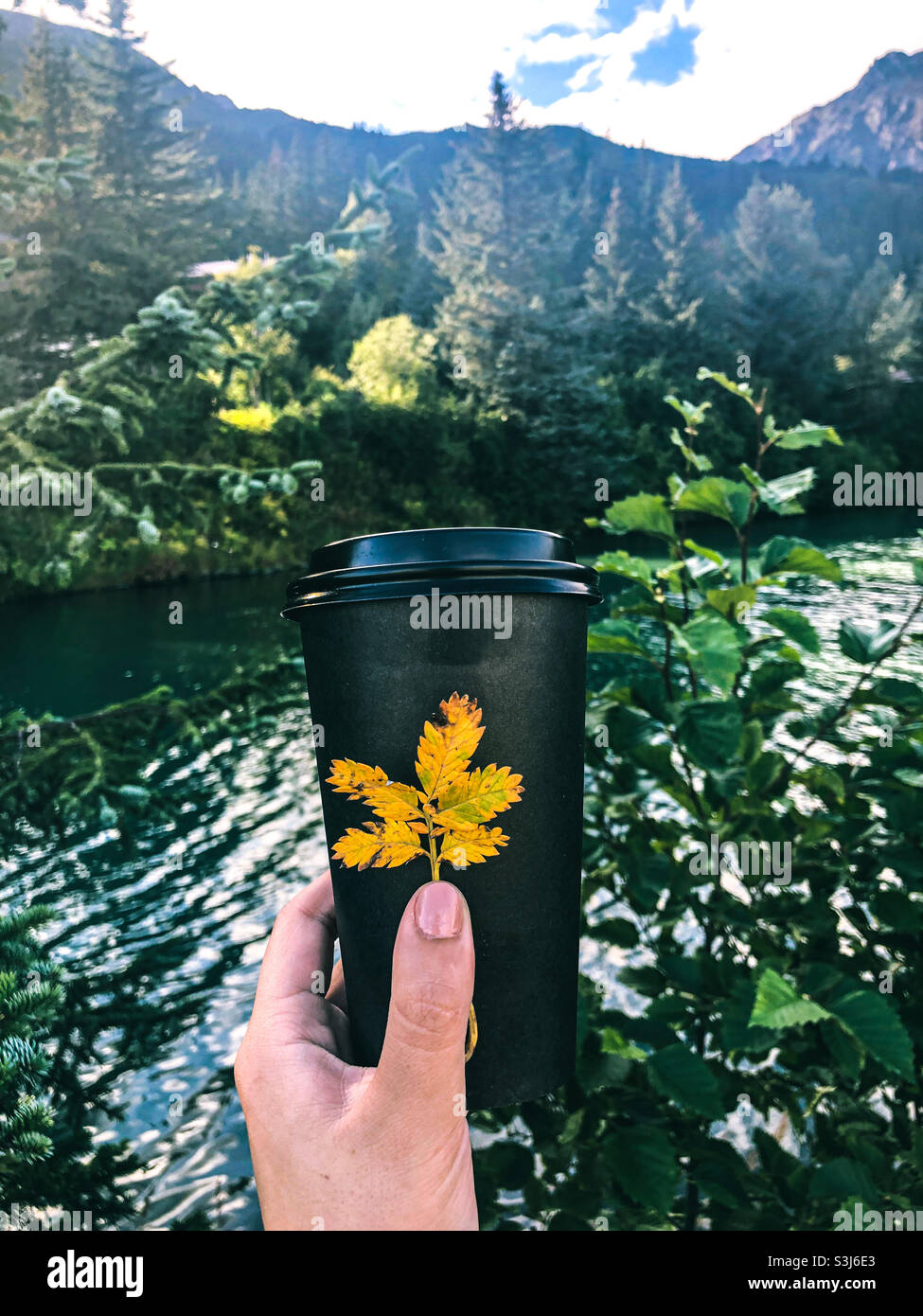 Tazza di caffè vicino a un fiume dell'Alaska! Foto Stock