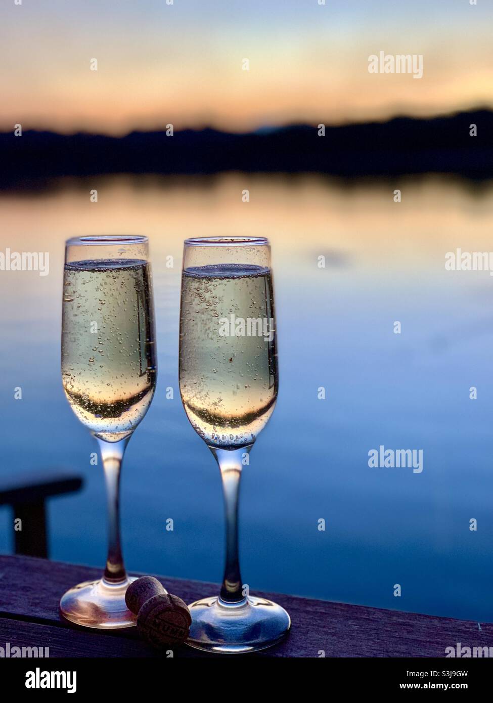 Champagne flautes lago tramonto Foto Stock