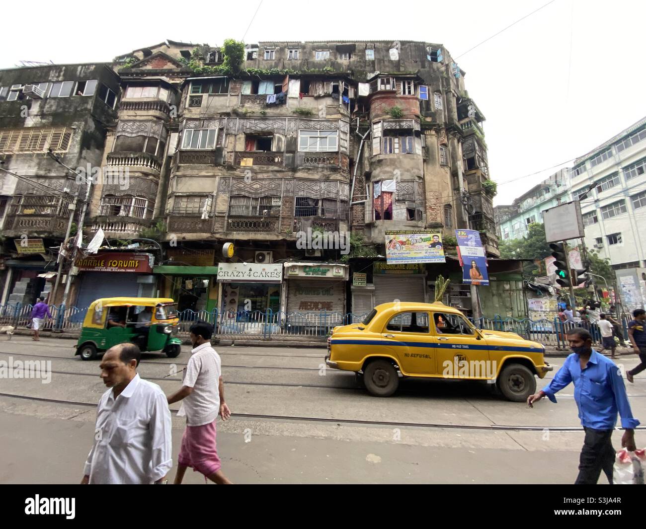 Taxi giallo che attraversa la strada della città patrimonio Kolkata - Immagine stock catturata con smartphone
