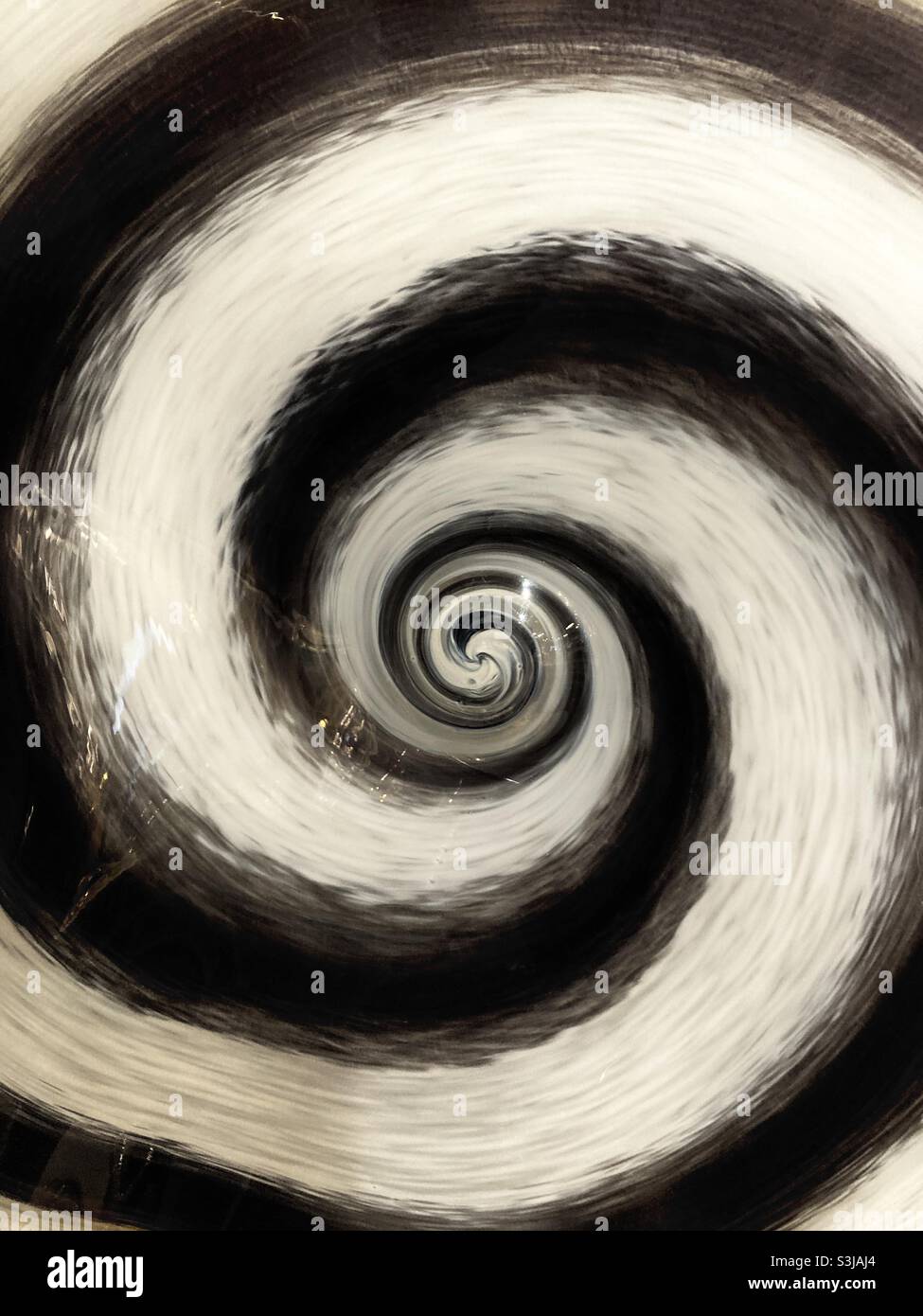 Un design a spirale in vetro soffiato a mano in bianco e nero - Immagine stock catturata con smartphone