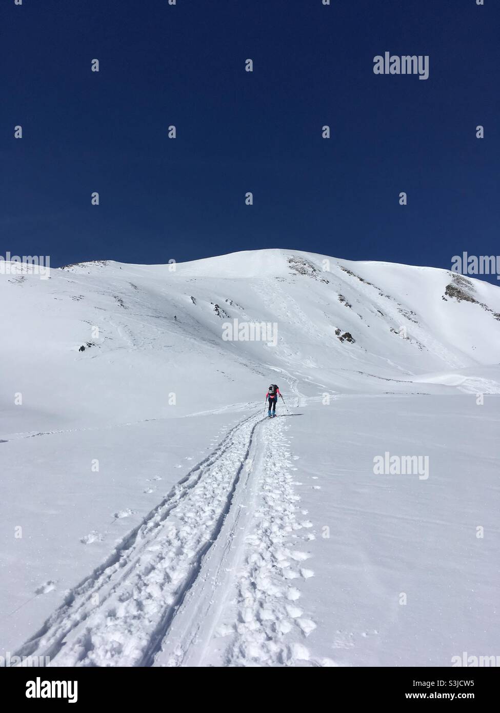 Persona solitaria e pista da sci nel paesaggio invernale nevoso delle Alpi - Immagine stock catturata con smartphone