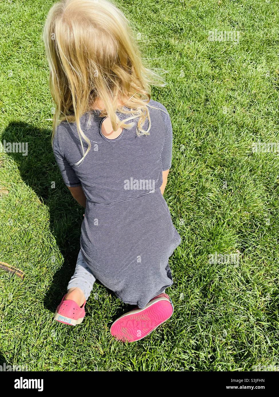 Scarpe rosa per bambini su erba verde - Immagine stock catturata con smartphone