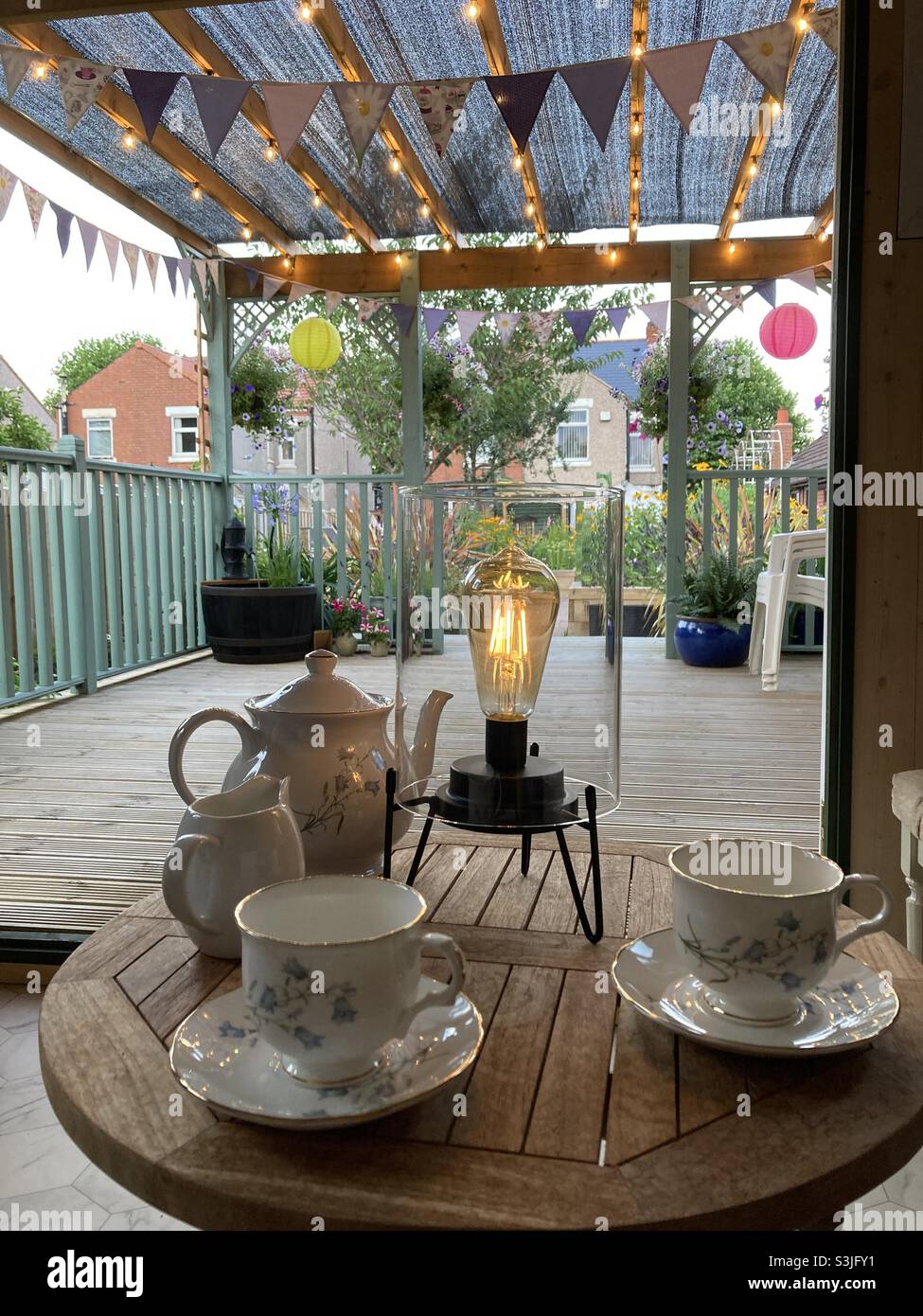 Vista dalla casa estiva in prima serata in giardino con teacups teiera - Immagine stock catturata con smartphone