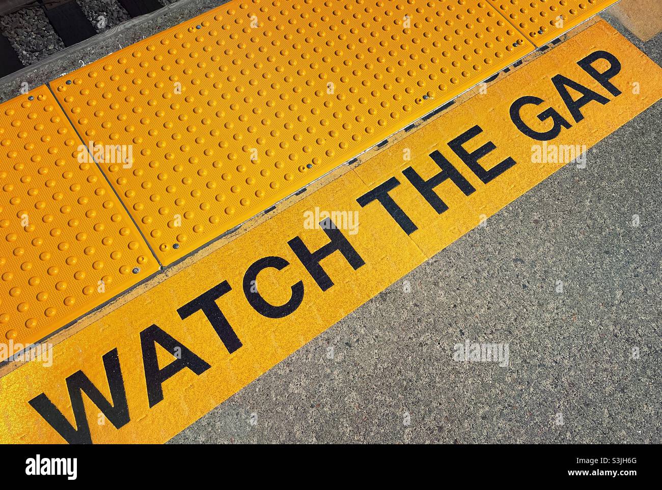 Guarda che il gap è un avvertimento visivo sul pavimento della piattaforma della stazione per la sicurezza dei passeggeri, 2021, USA - Immagine stock catturata con smartphone