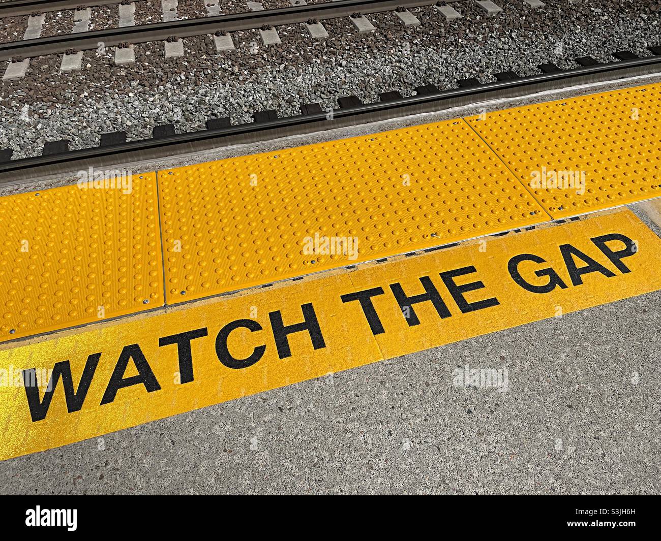 Guarda lo stencil di avvertimento gap in una stazione ferroviaria del penduter, 2021, USA - Immagine stock catturata con smartphone