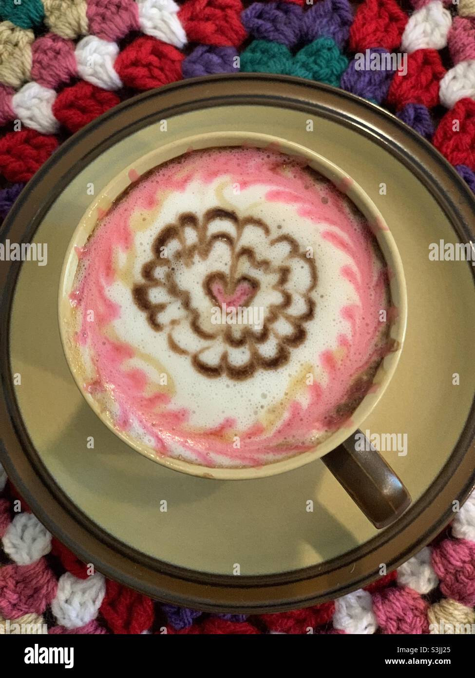 Latte art con cuore rosa di San Valentino sotto un tostapane in maglia Foto Stock