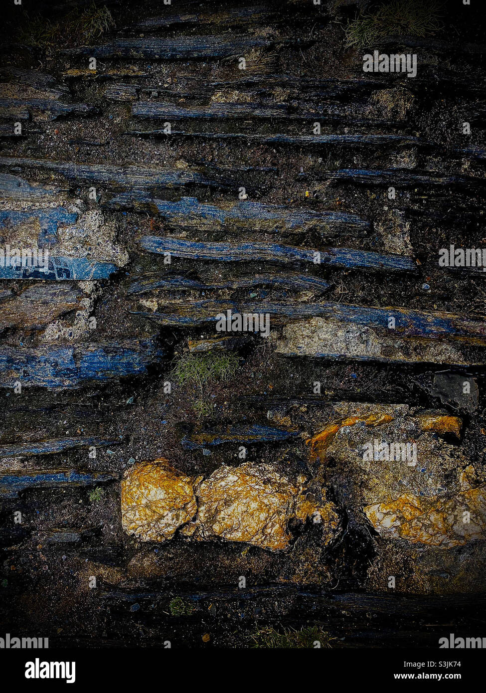 immagine ravvicinata di diverse pietre incastonate in una scogliera in una spiaggia in cornovaglia, inghilterra - Immagine stock catturata con smartphone