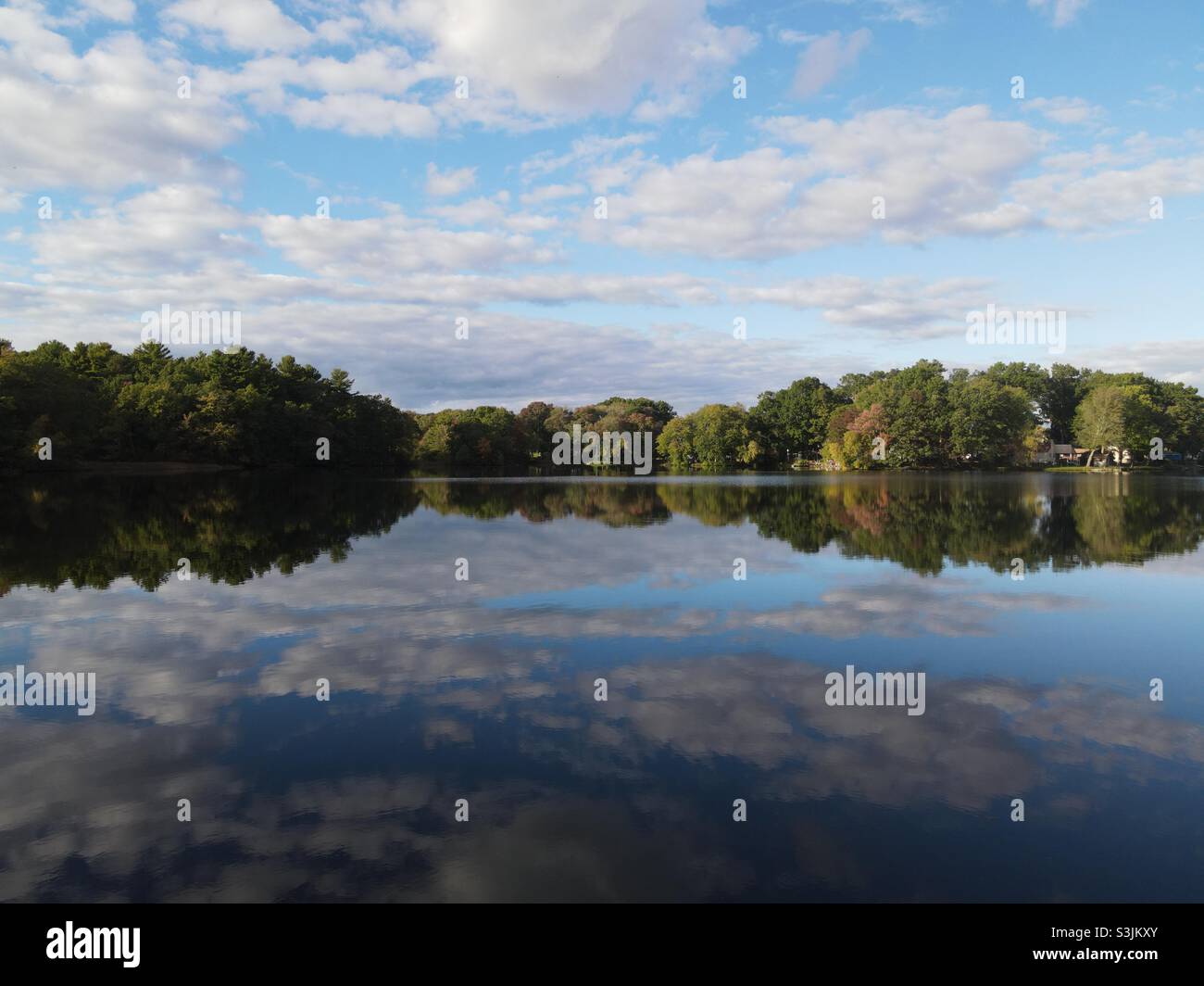Cielo che si riflette su un lago fermo in un perfetto pomeriggio autunnale Foto Stock