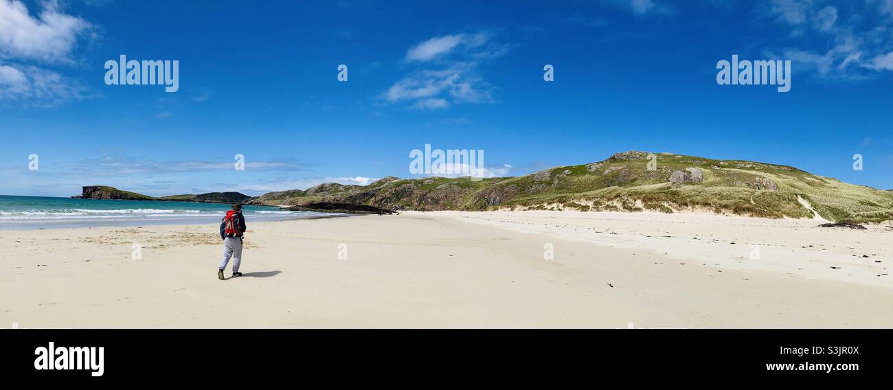 Uomo che cammina lungo la spiaggia di Oldshoremore Beach sulla costa settentrionale 500. Scozia Foto Stock