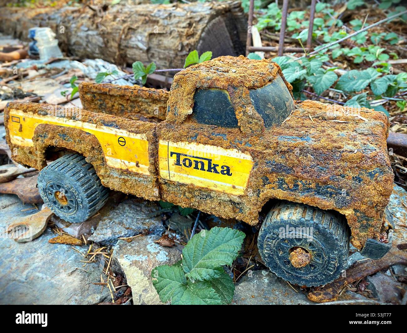 Un giocattolo Tonka camion all'aperto e coperto di ruggine spessa. Foto Stock