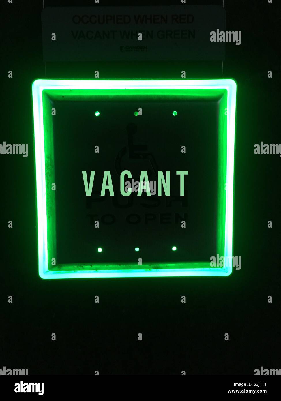 Cartello vuoto. Verde significa non occupato, premere per l'ingresso, disponibile, libero. Qui, al di fuori di un moderno bagno accessibile con sedia a rotelle, di tutti i generi, Ontario, Canada. - Immagine stock catturata con smartphone