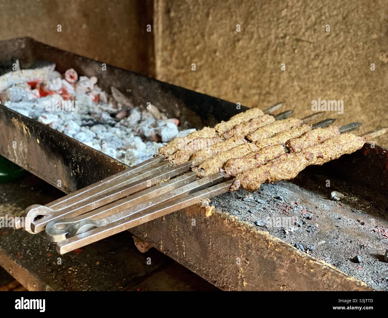 Seekh kebab, piatto popolare per i musulmani in india, fatto di manzo. E 'grigliato sul fuoco di carbone. Foto Stock