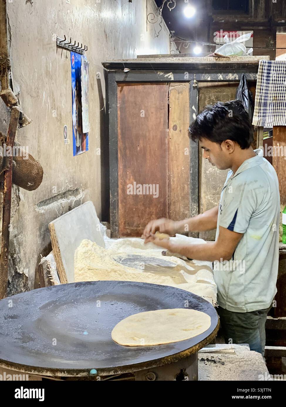 Il personale ha preparato chapatis o roti, meglio conosciuto come pane piatto indiano al ristorante. Composto principalmente da due farine, farina di grano e farina raffinata. - Immagine stock catturata con smartphone