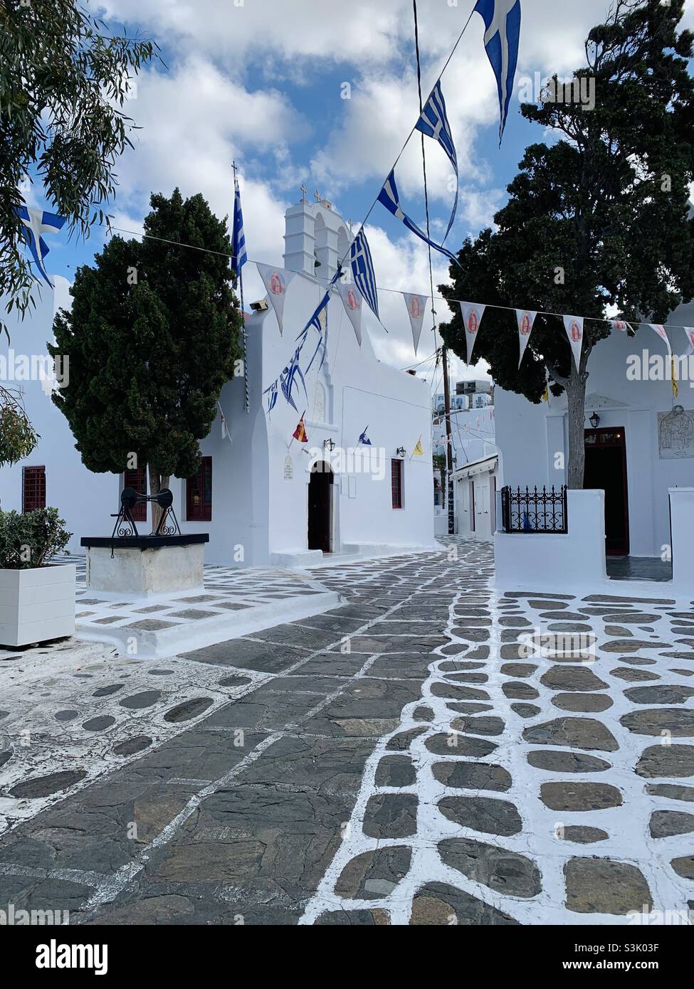 Scena di strada della chiesa a Mykonos con strada ciottolata Foto Stock