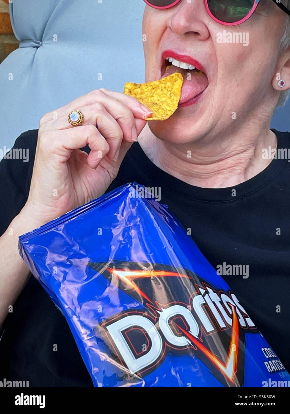 Donna anziana che mangia Doritos, 2021, USA - Immagine stock catturata con smartphone