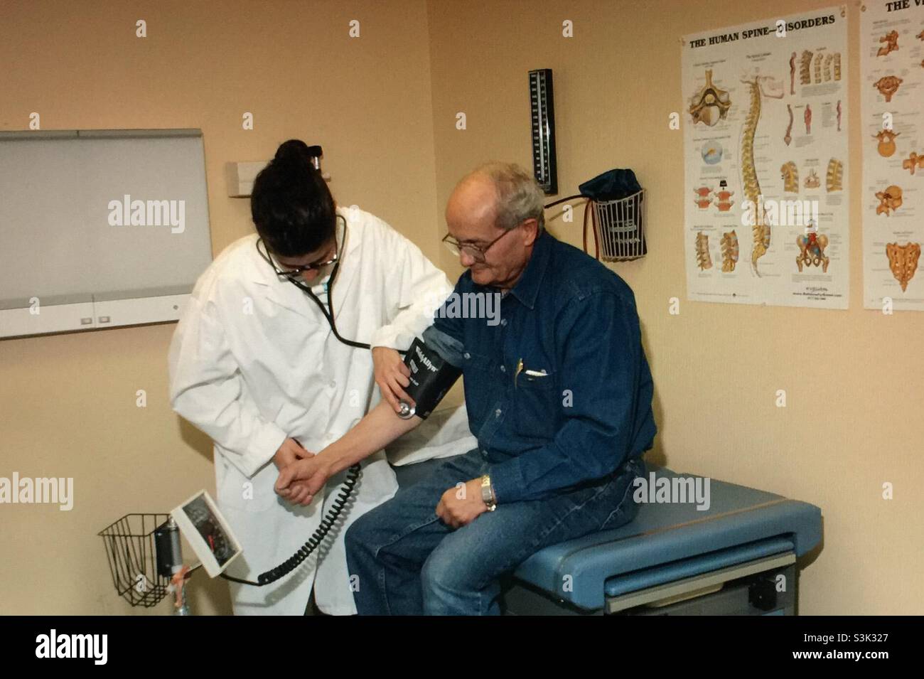 Medico che prende la pressione sanguigna e paziente - Immagine stock catturata con smartphone