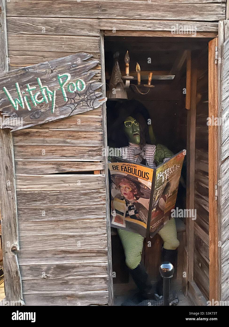 Il "WitchFest" di Gardner Village ogni ottobre è uno dei preferiti dalle famiglie per i residenti di Salt Lake, Utah. Qui si trova una strega che legge un articolo mentre si visita il “WitchyPoo”, o la corte delle streghe. Foto Stock