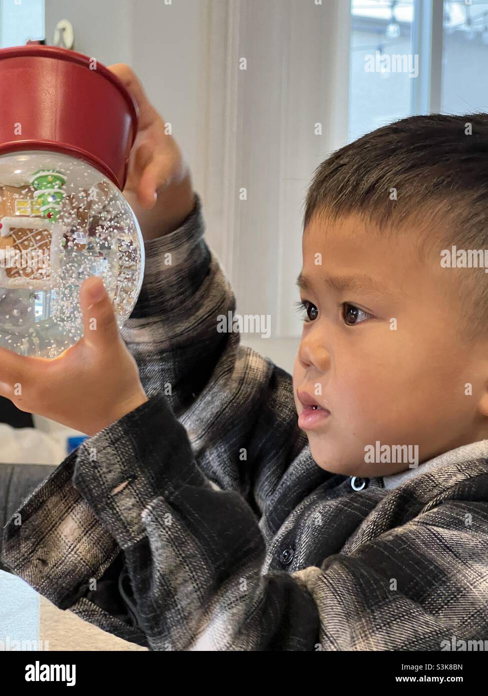 Ragazzo stupito, ragazzo curioso, Boy Winter Snow Globe, Winter Wonderland, Winter Globe, Winter Snow Globe, Winter Snow Globe, neve d'inverno globo. - Immagine stock catturata con smartphone