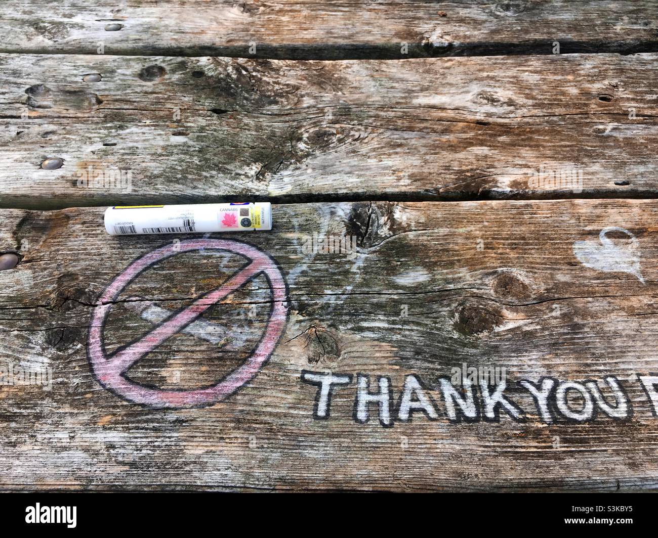 Messaggio contraddittorio: Grazie per non aver fumato, a meno che non si tratti di cannabis. Grafica, parole, oggetto su una panca di parco, all'aperto, Ontario, Canada. La marijuana in tutte le forme è popolare dopo la legalizzazione. - Immagine stock catturata con smartphone