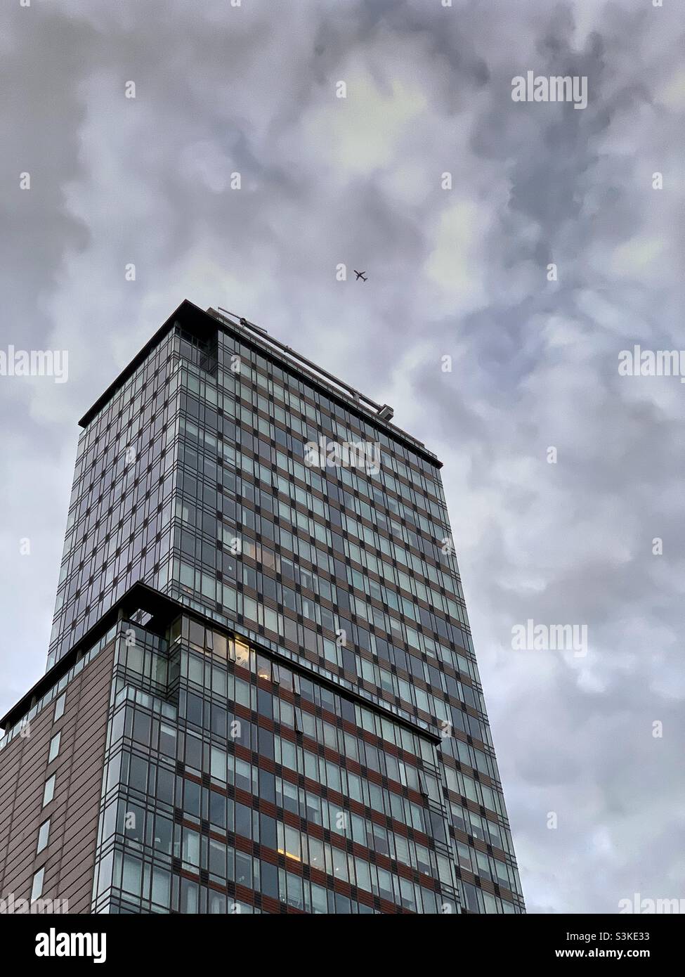 Un edificio e un aeroplano con sfondo cloud. - Immagine stock catturata con smartphone