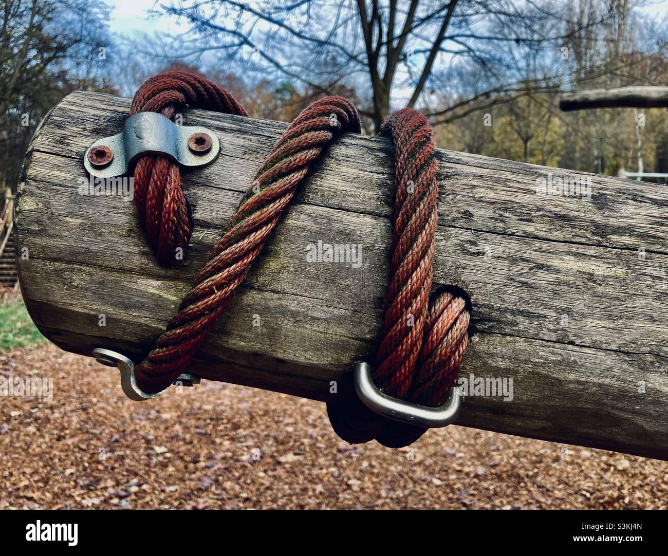 Una corda rossa è avvolta intorno ad una trave grigia di legno - Immagine stock catturata con smartphone