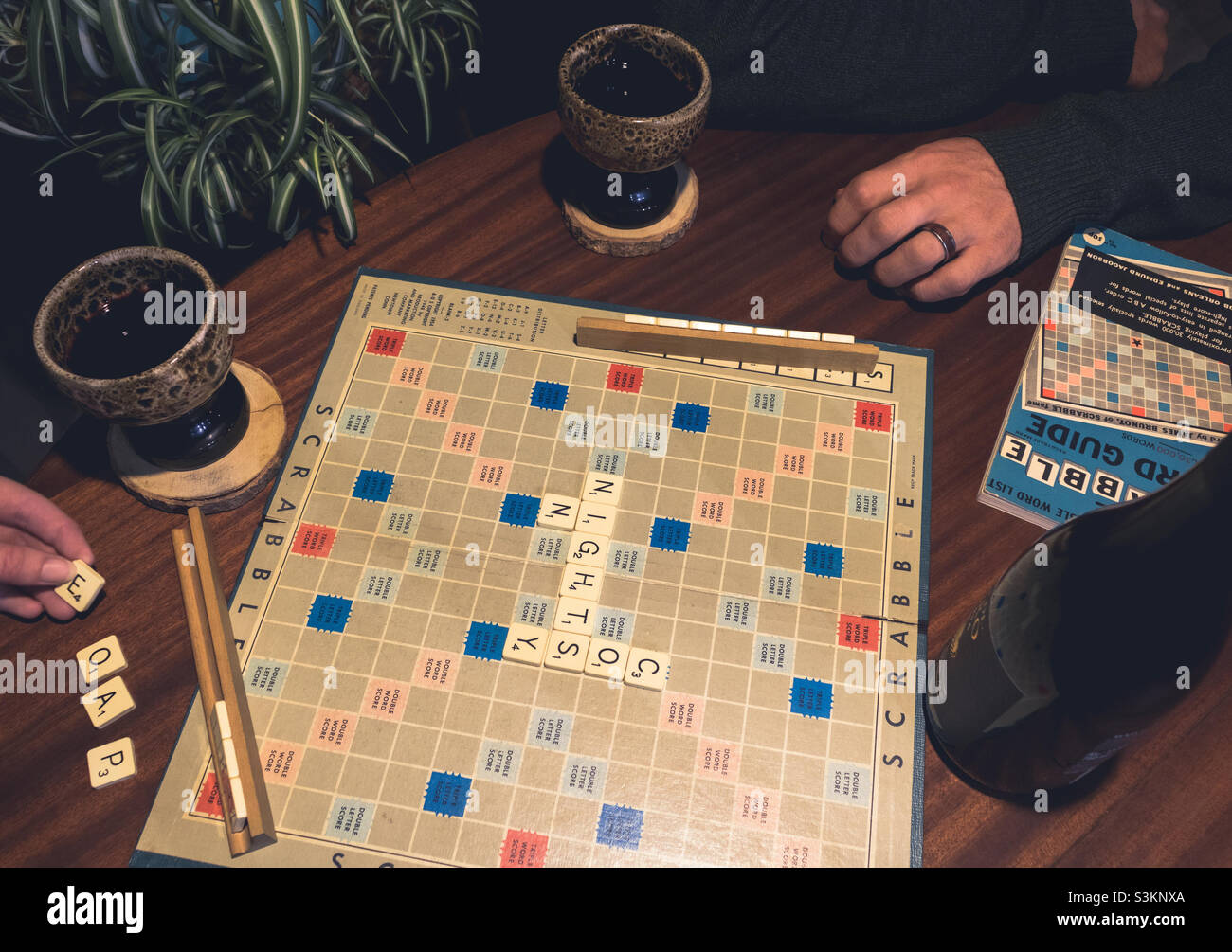 Notti accoglienti, giocare scrabble e bere vino Foto Stock