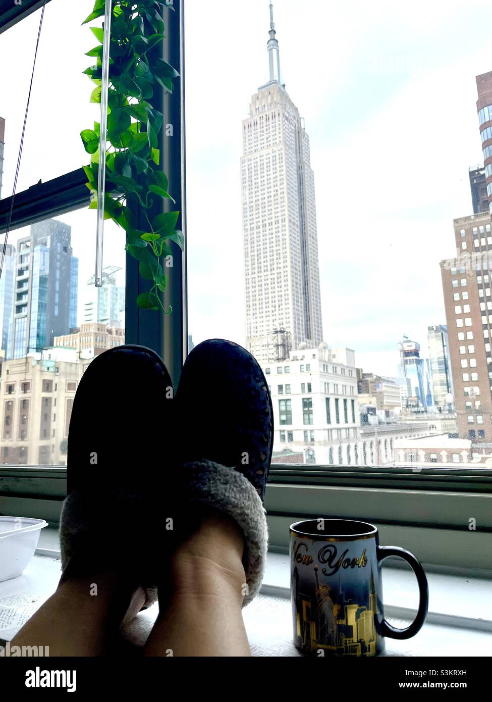 Mettiti in piedi e rilassati con una splendida vista sull'Empire state Building di New York. Foto Stock