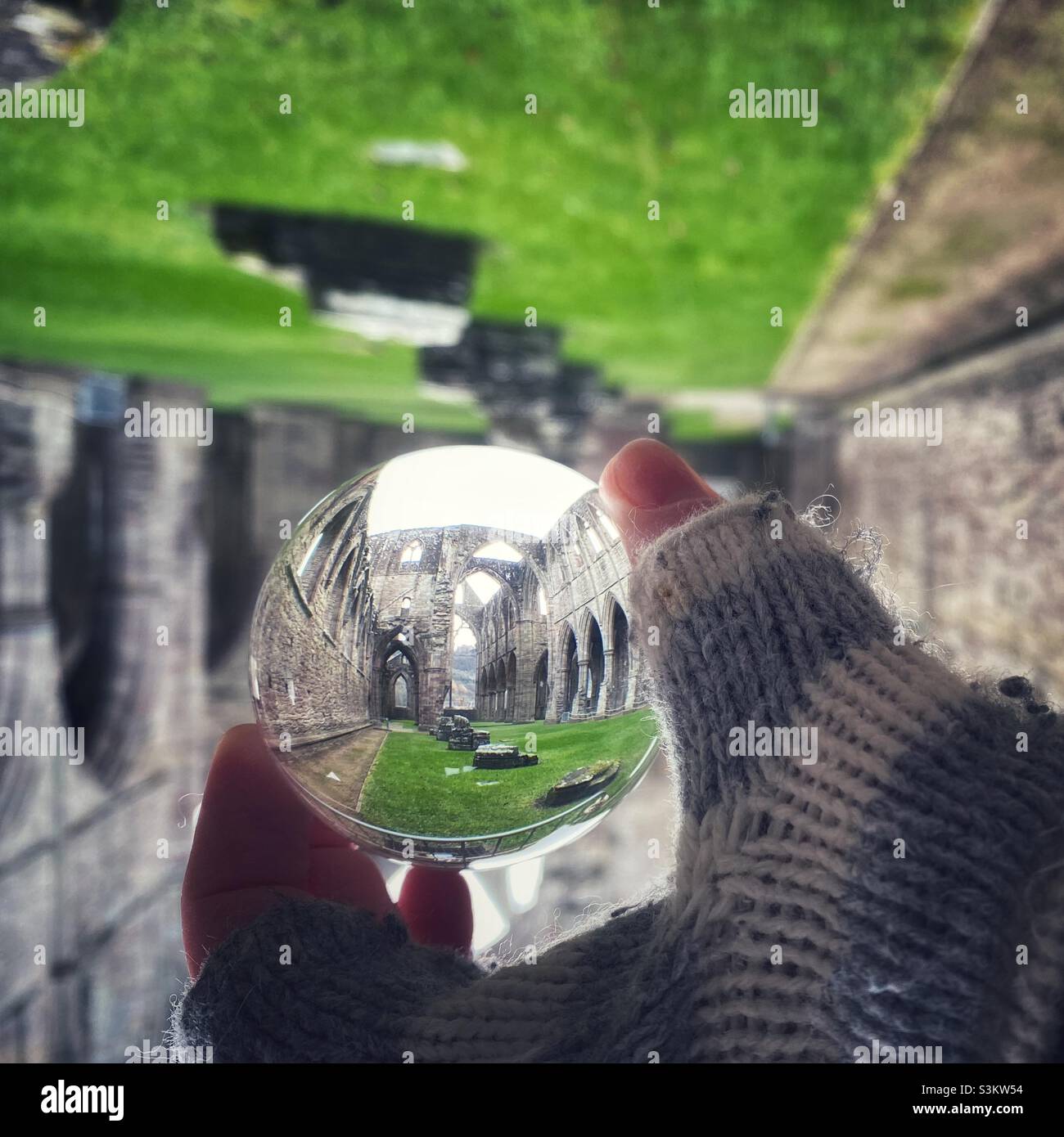 Una fotografia all'interno dell'abbazia di Tintern in Galles attraverso un orb di vetro Foto Stock