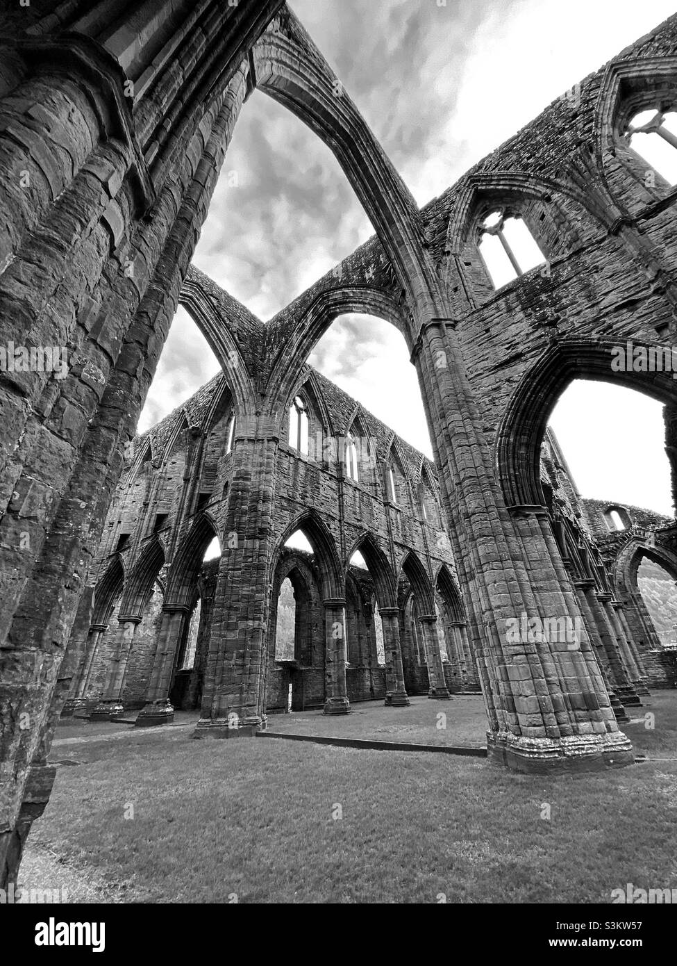 Una fotografia all'interno dell'Abbazia di Tintern, in bianco e nero, della struttura e dell'architettura delle rovine Foto Stock