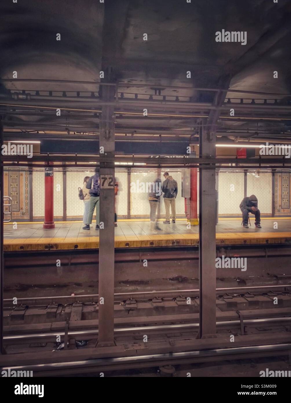 Persone in attesa sul treno a 72nd Street, Manhattan, New York. - Immagine stock catturata con smartphone