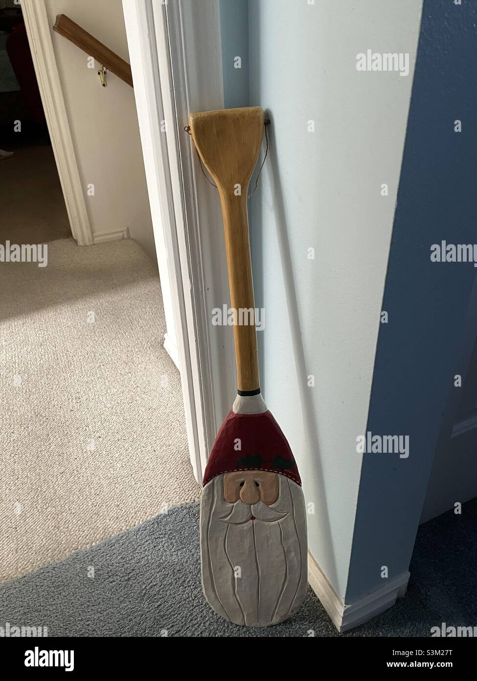 Trovato in un negozio di Thrift, questo Babbo Natale scolpito e dipinto è unico, in quanto è integrato come parte di un remo, o pagaia. Foto Stock