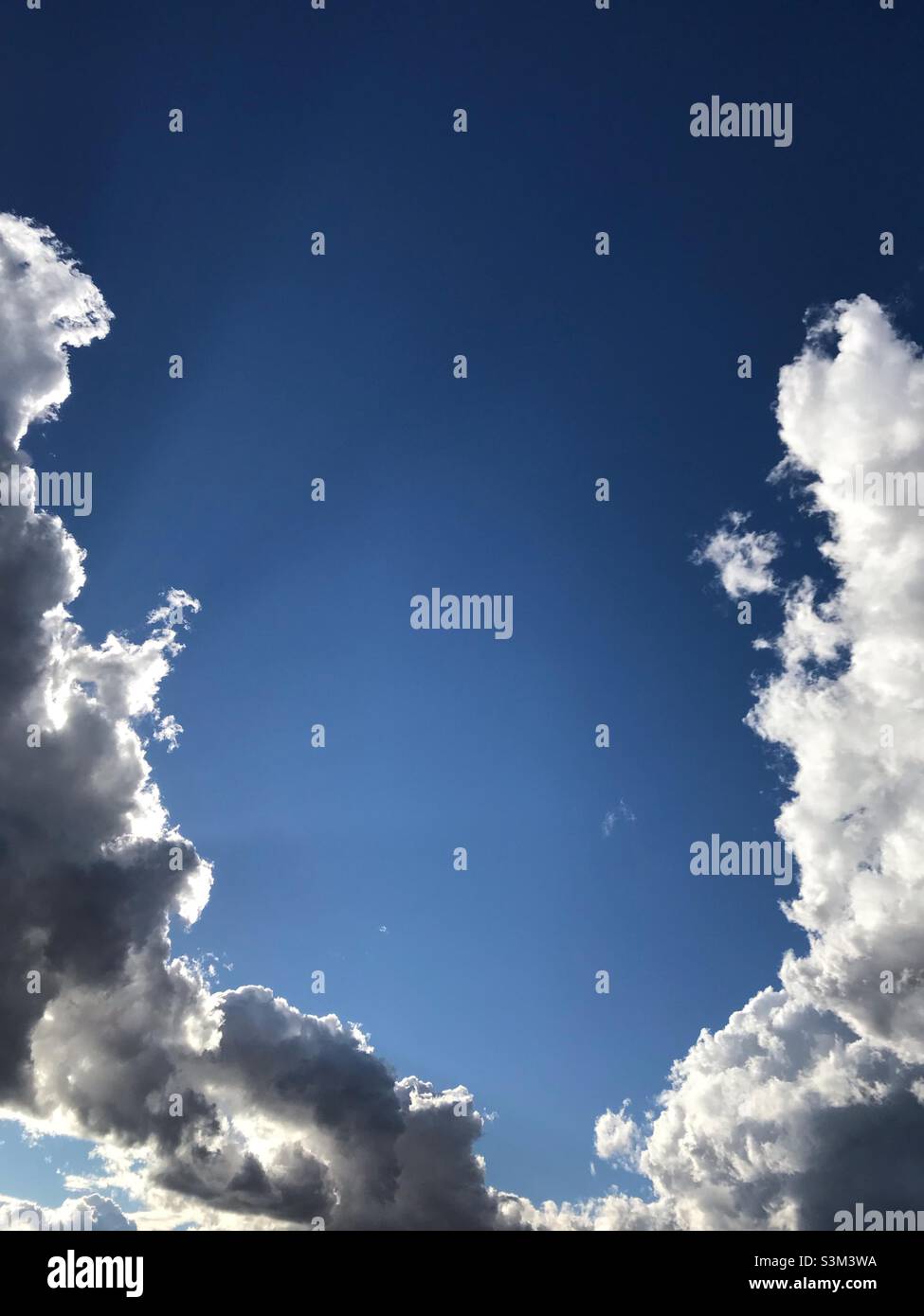 Nuvole che si uniscono con un cielo blu in attesa di una tempesta imminente Foto Stock