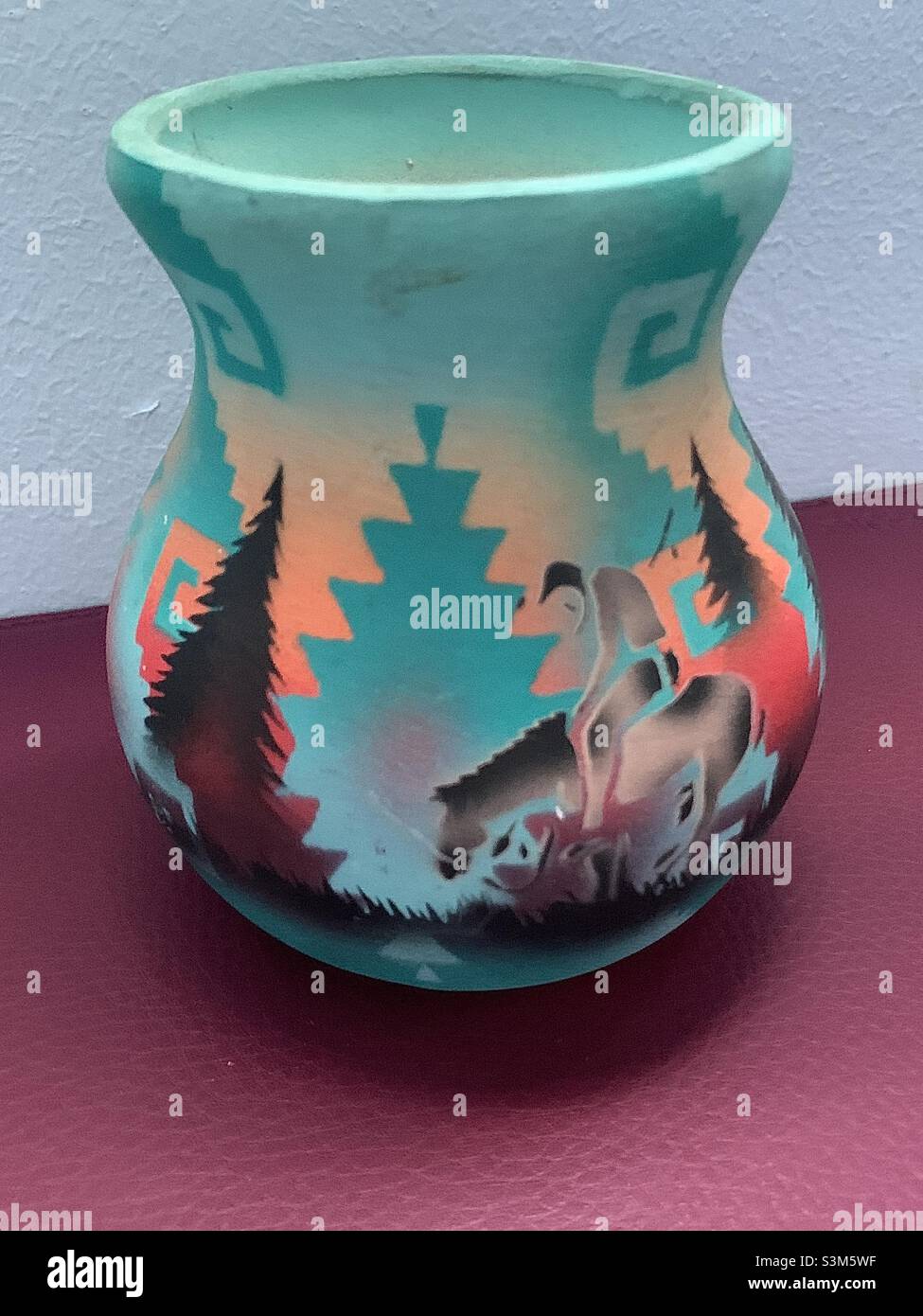Le ceramiche native americane mostrano il pilota svezzato su un cavallo in una natura selvaggia turchese e arancione di stile sud-occidentale. - Immagine stock catturata con smartphone