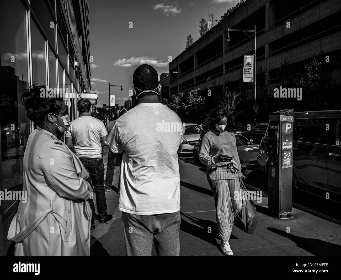 Persone in coda in attesa di entrare in Food Cellar negozio di alimentari fantasia a Long Island City, New York, a causa di ridurre le restrizioni di occupazione durante i primi giorni della pandemia di Covid 19 Foto Stock