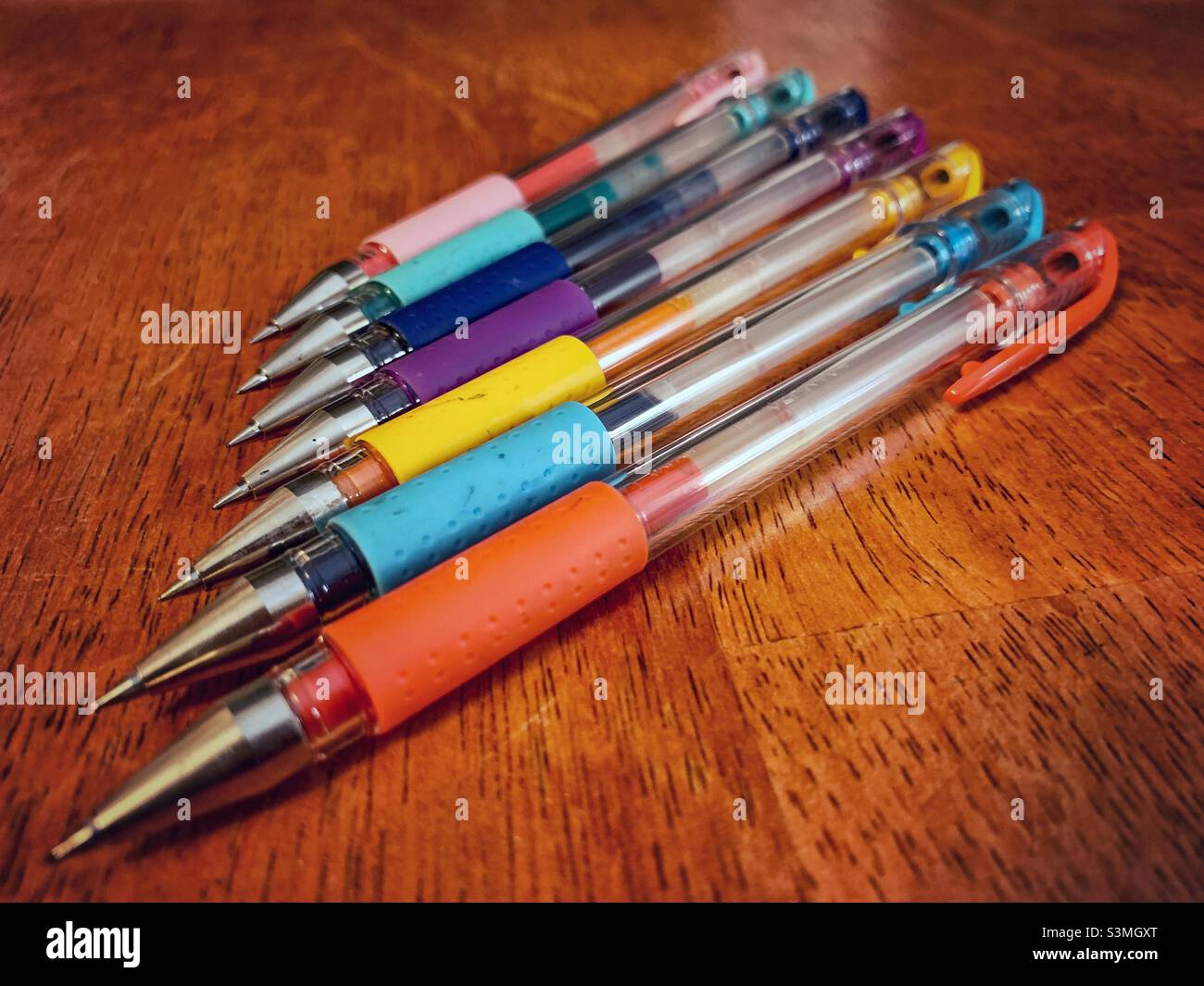 Colori diversi delle penne su sfondo marrone. Foto Stock