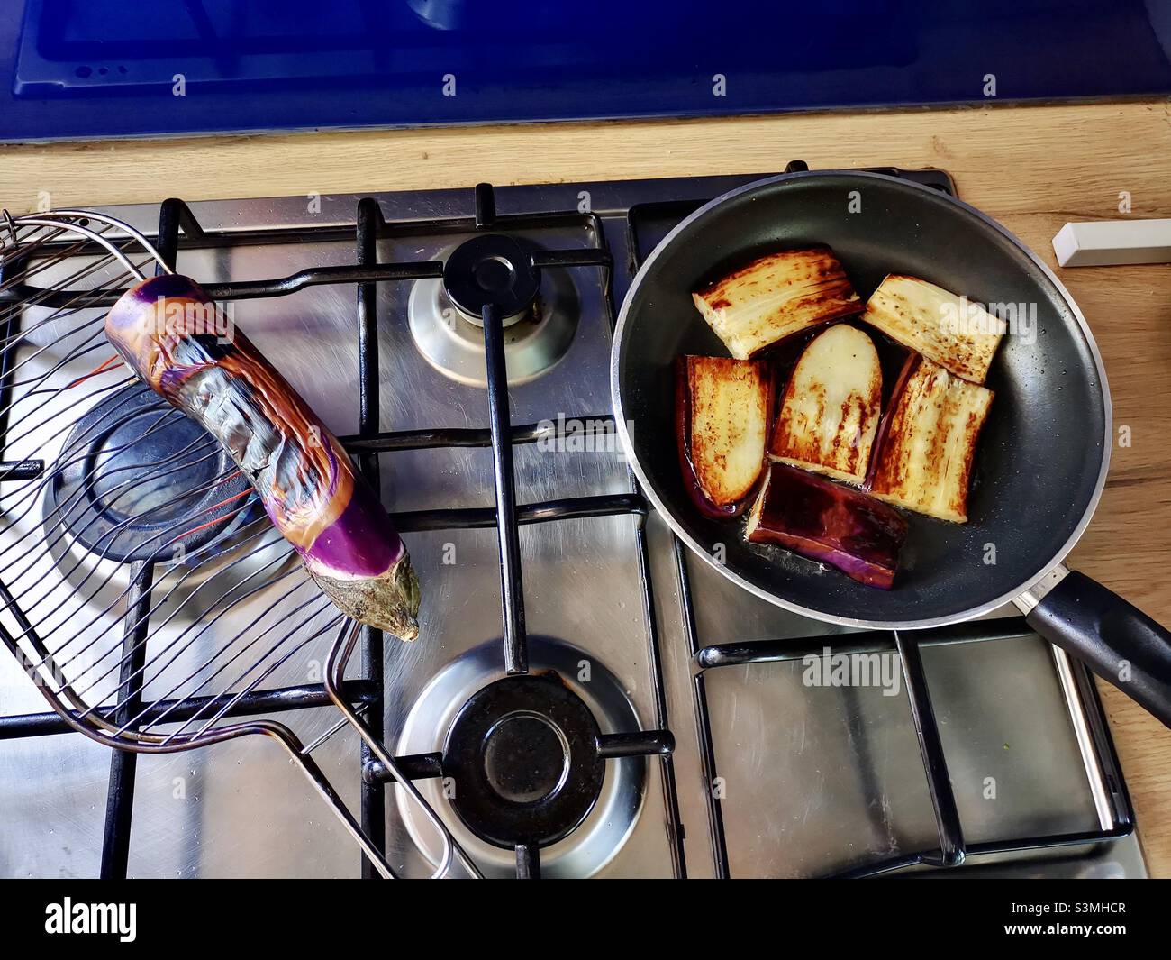 Tostatura e frittura di melanzane in stufa. - Immagine stock catturata con smartphone